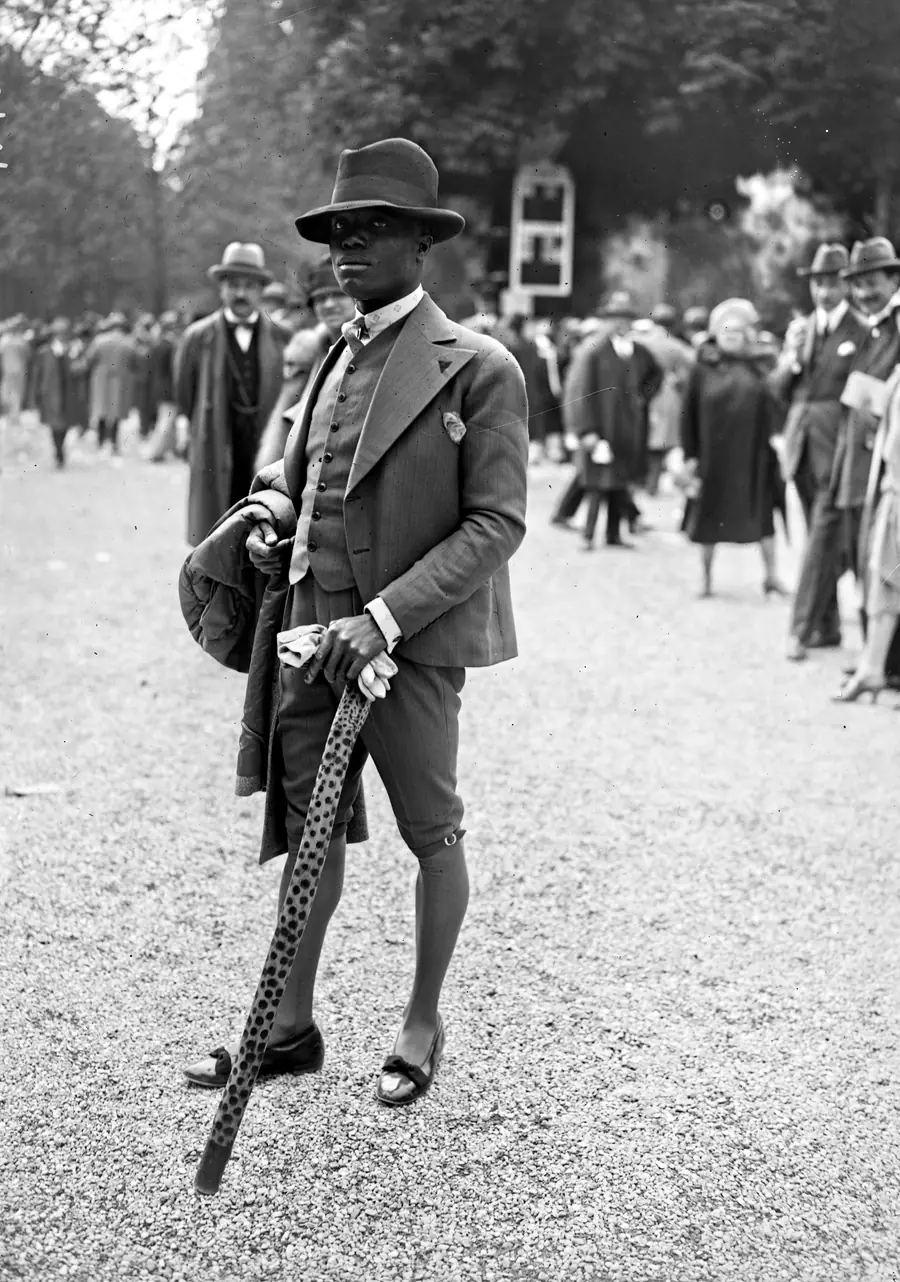 A gentleman in a tailored suit and hat at the races